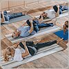 senior people with instructor stretching and exercising on yoga mats at training class