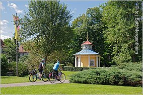 Schellenhäuschen mit Radfahrern im Schlosspark